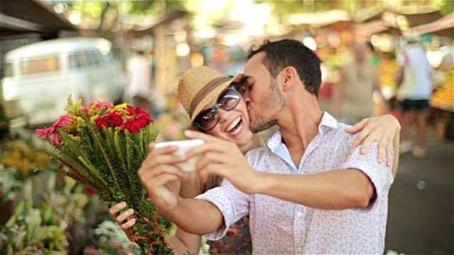 мужчина делает селфи, подарив женщине цветы